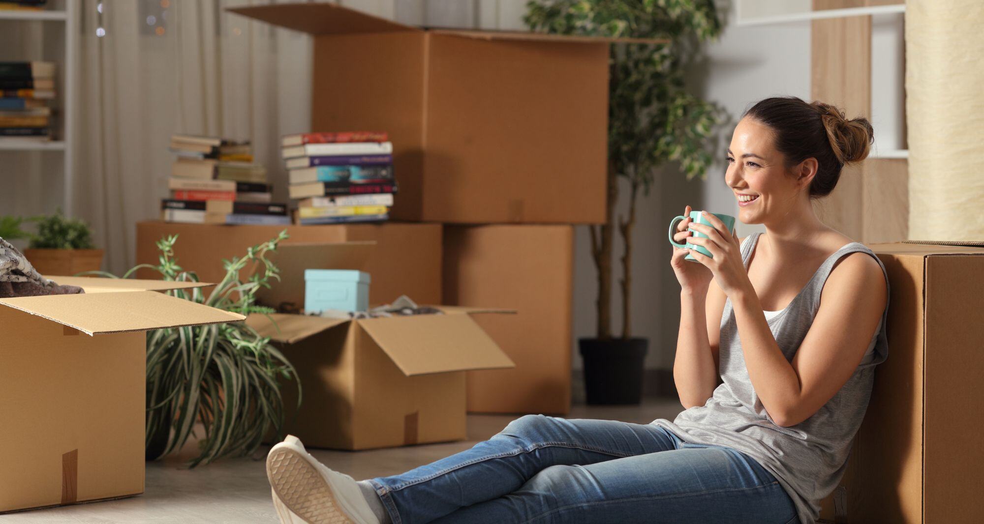 Jeune femme profitant d'une pause café pendant son déménagement - déménager seul